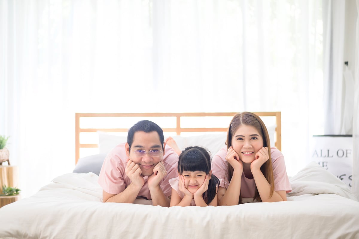 portrait of happy Asian family in white bedroom